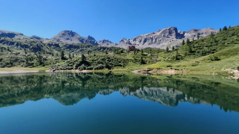 lago rotondo e sullo sfondo il rifugio calvi