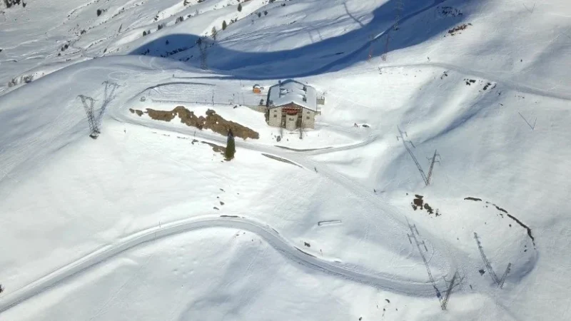 Vista aerea del rifugio e della strada innevata a tornanti